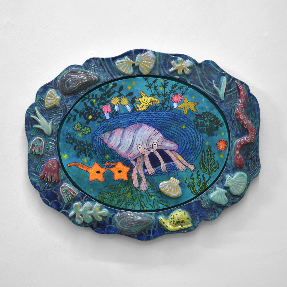 Oeuvre unique de Fanny Mesnard. Acrylique sur toile et encadrement en céramique. Un monde sous-marin imaginaire avec crustacées, anguilles, étoiles de mer et escargots.