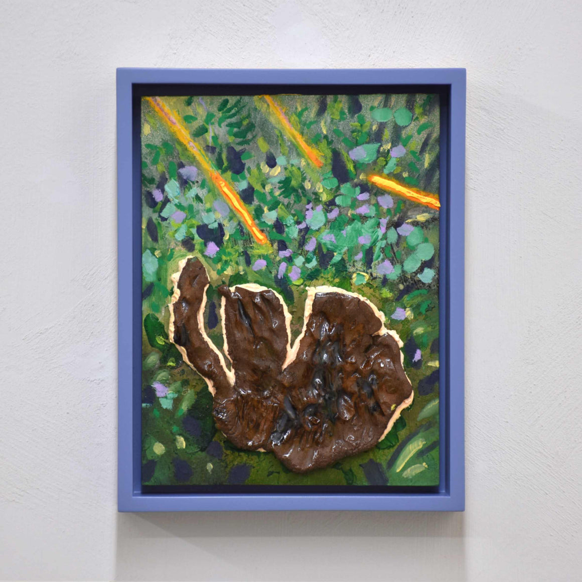 Branches fluos, de Josiane Lanthier. Acrylique et céramique sur panneau de bois, 8” x 10” avec cadre violet. Branches oranges fluos dans du gazon vert avec une grosse pierre brune.