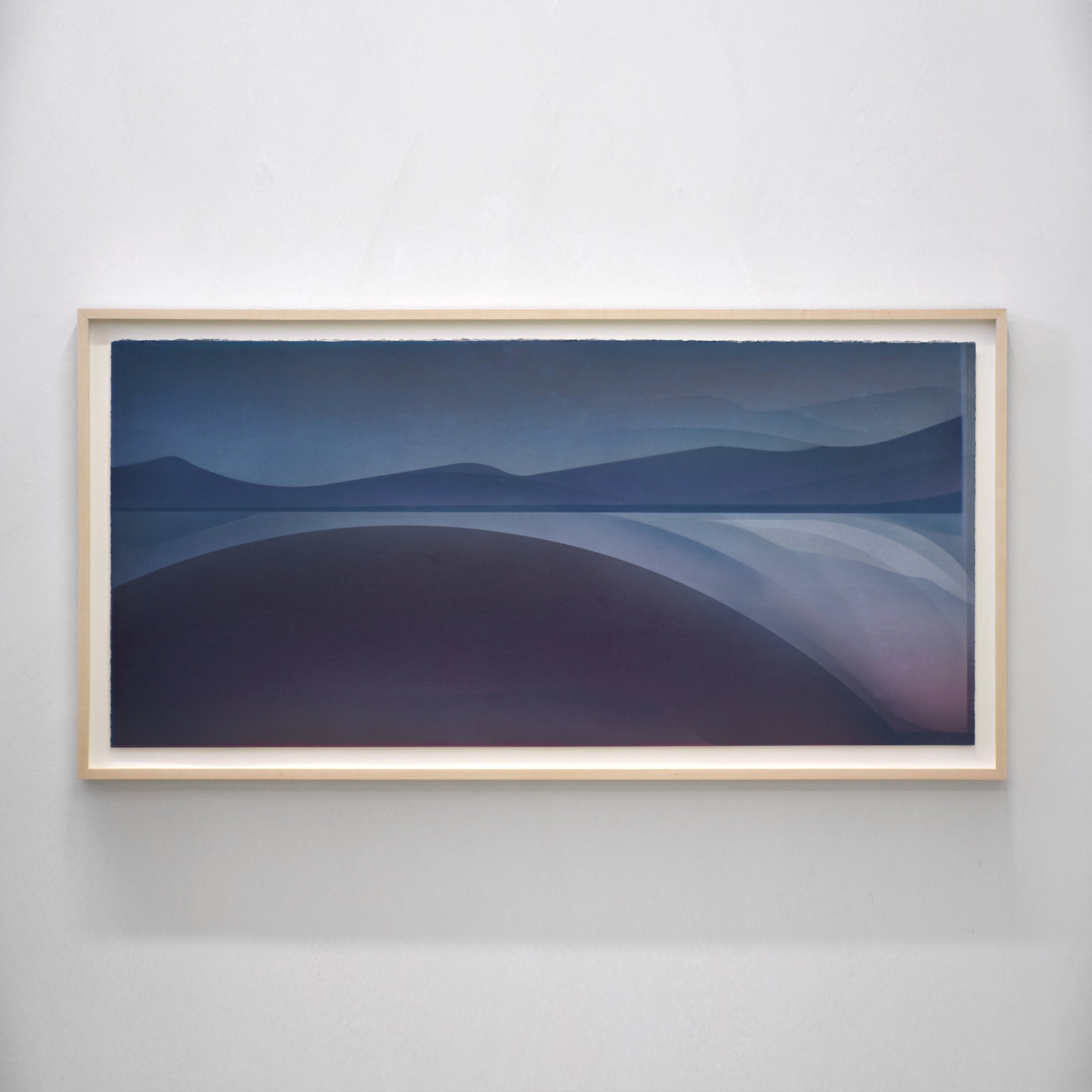 Succomber à l’envier, par Jason Cantoro. Acrylique sur papier coton Somerset, 24” x 47” avec cadre en érable. Composition bleu avec horizon de montagnes sur le fleuve Sainte-Laurent.