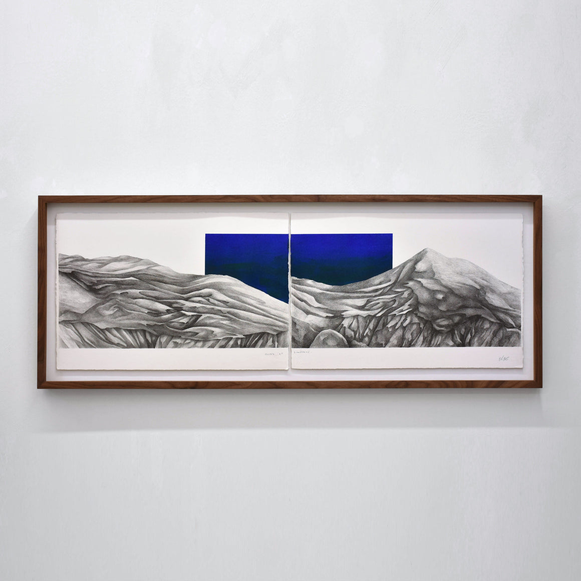 Diptyque d’Elisabeth Gravel dans un grand cadre en noyer, des montagnes dessinées à l’encre noire et un ciel bleu outremer 