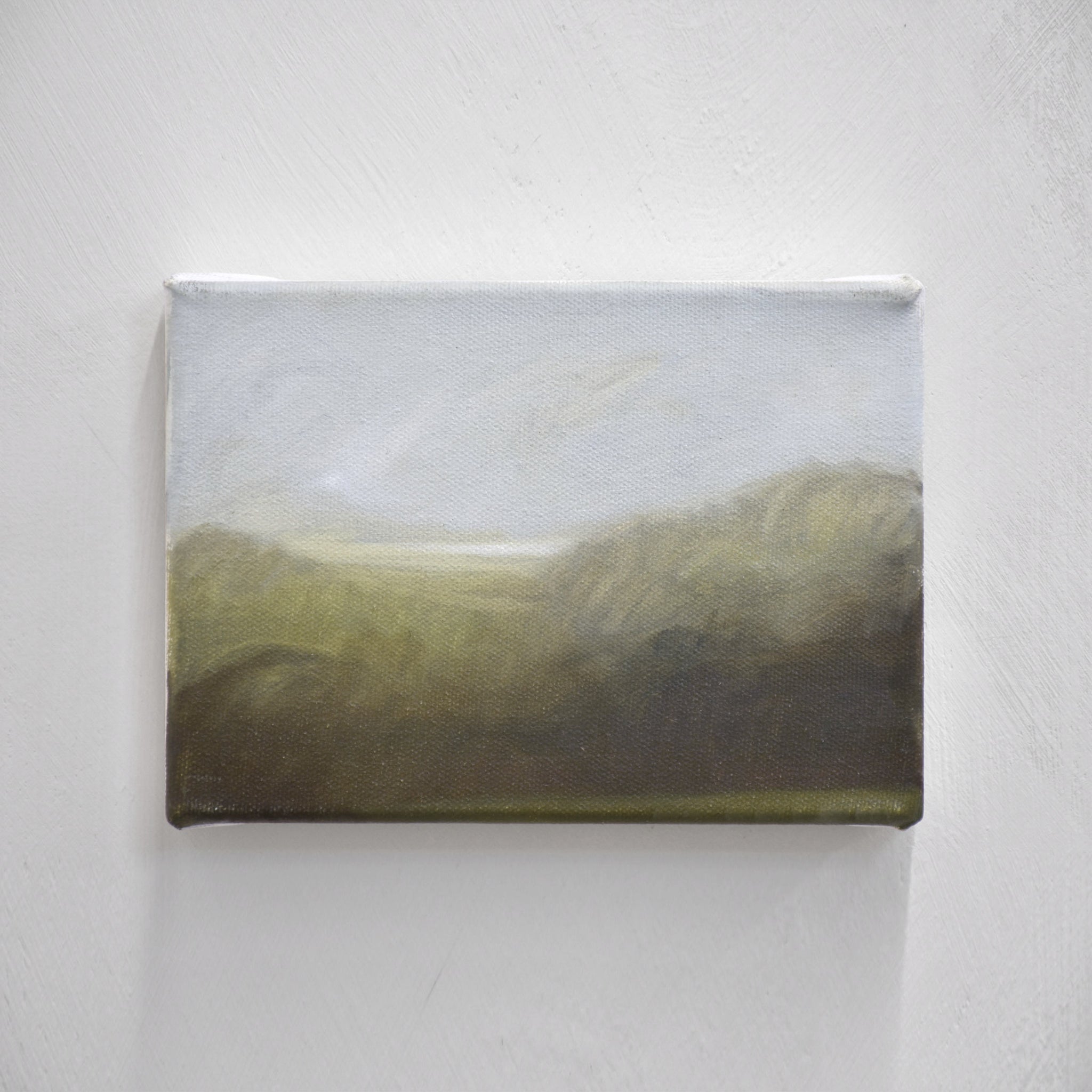 Étude à l’huile par Vanessa Locatelli. Une éclaircie au loin traverse les collines verdoyantes de Charlevoix.