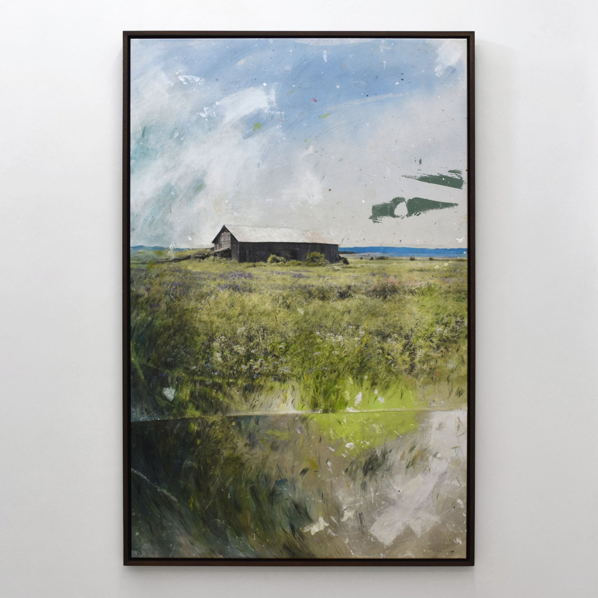 Grand format vertical de Chloé Giroux-Bertrand. Sur l’horizon du fleuve Saint-Laurent, on voit la grange de la Rivière-aux-Vases derrière les herbes hautes.