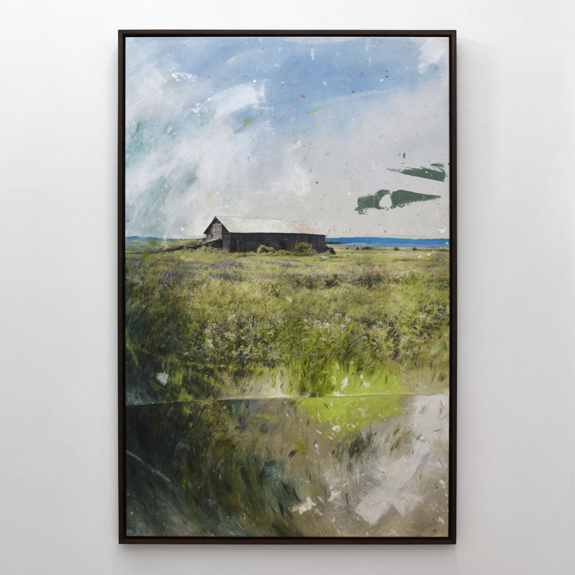 Grand format vertical de Chloé Giroux-Bertrand. Sur l’horizon du fleuve Saint-Laurent, on voit la grange de la Rivière-aux-Vases derrière les herbes hautes.