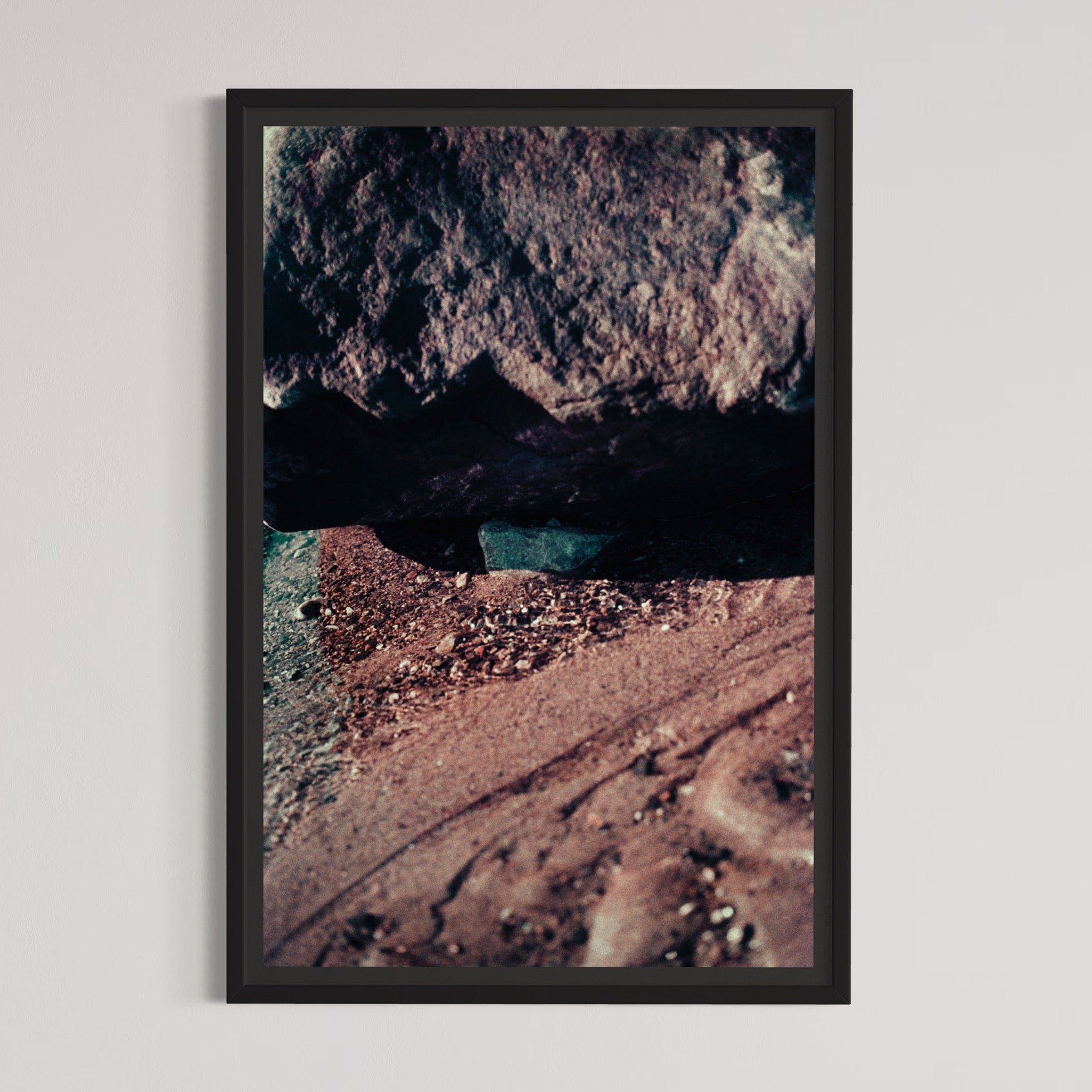 L’indépendante, par Éva-Maude TC. Photographie contemporaine sur pellicule 35 mm, 16” x 24”, 2024. Un caillou bleu se cache entre deux rochers roses de bord de fleuve.