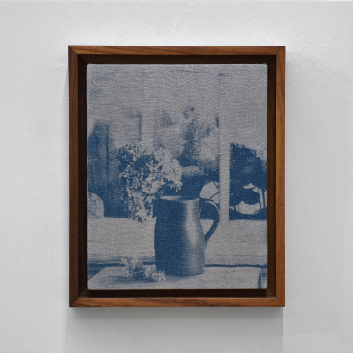 La maison de Sarah, par Caroline Bolieu. Impression par cyanotype sur tissu, encadrement en noyer. Composition d’une nature morte dans un décor intérieur.