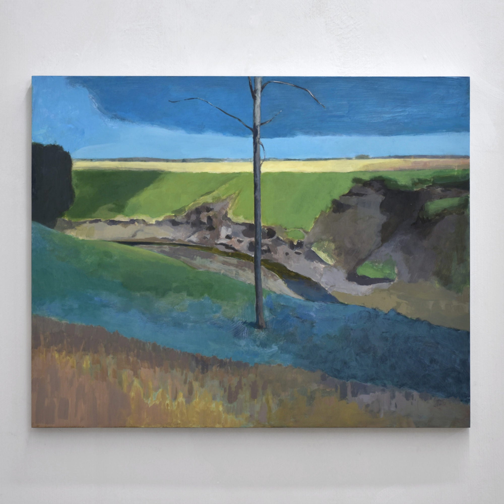 Le fossé, de Benoit Chartier. Acrylique sur panneau de bois, 24" x 30”, 2024. Un arbre au milieu d’un fossé avec un panorama sur des champs.