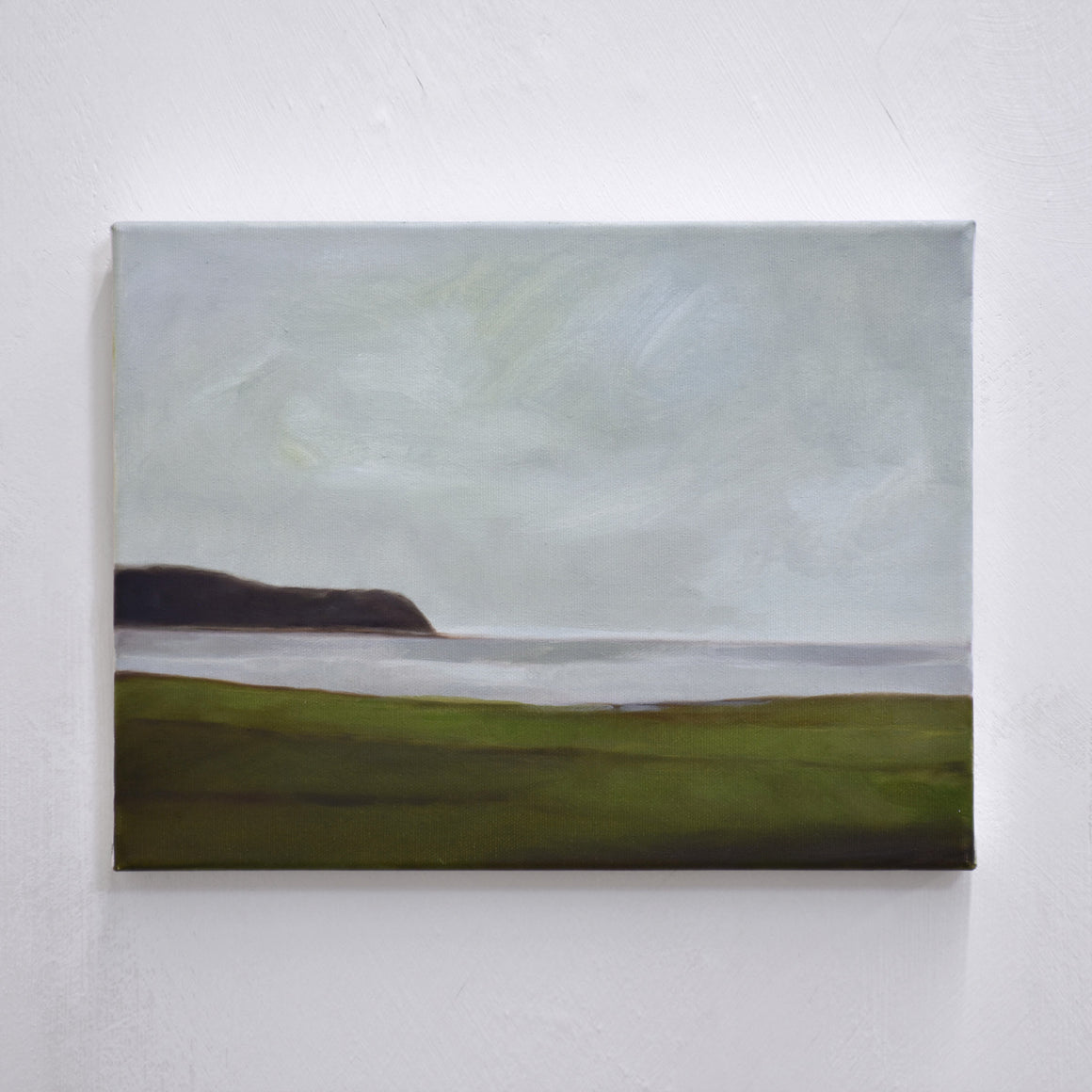 Une huile de toile de Vanessa Locatelli inspirée d’un paysage Irlandais. Des plaines verdoyantes sont exposées à la mer dans un paysage brumeux.