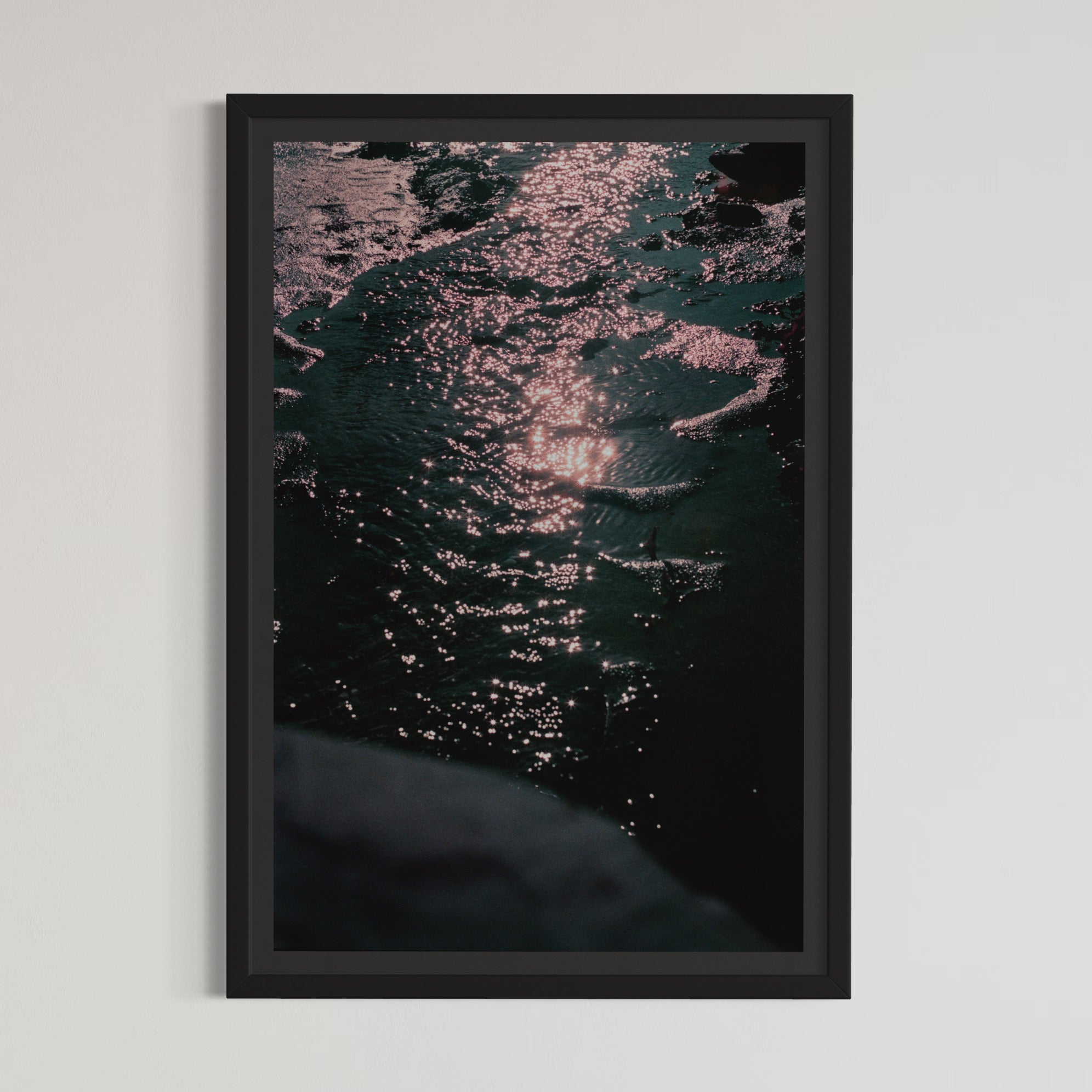 Les choses qui brillent II, par Éva-Maude TC. Photographie sur pellicule 35 mm, 12” x 18”, 2024. Éclat de lumière sur l’eau du fleuve à marée basse. Clair-obscur.