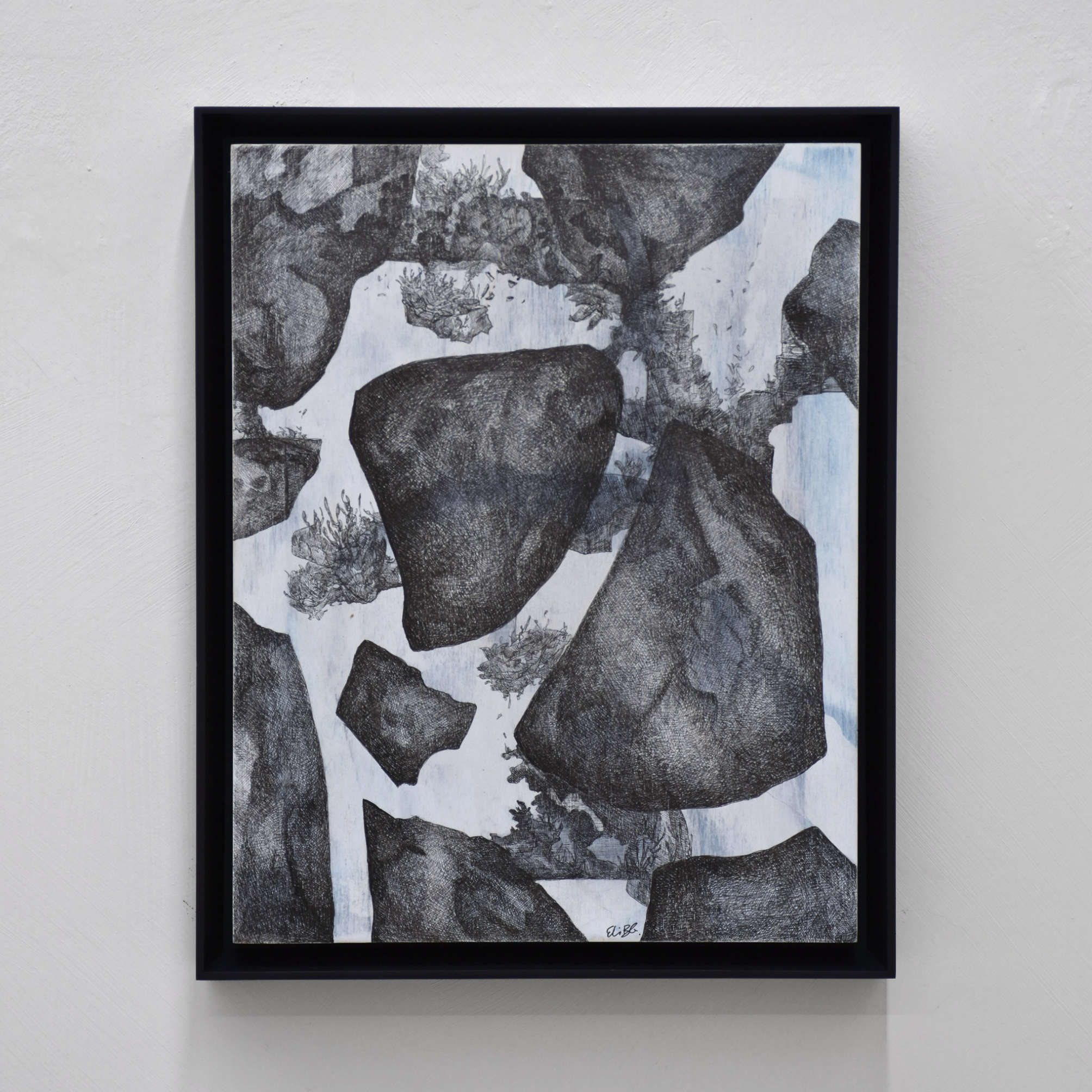 Les ombres suspendues, par Elisabeth Gravel. Dessin à l’encre noir sur panneau de bois vertical, cadre noir. Composition surréaliste de rochers et de végétation.