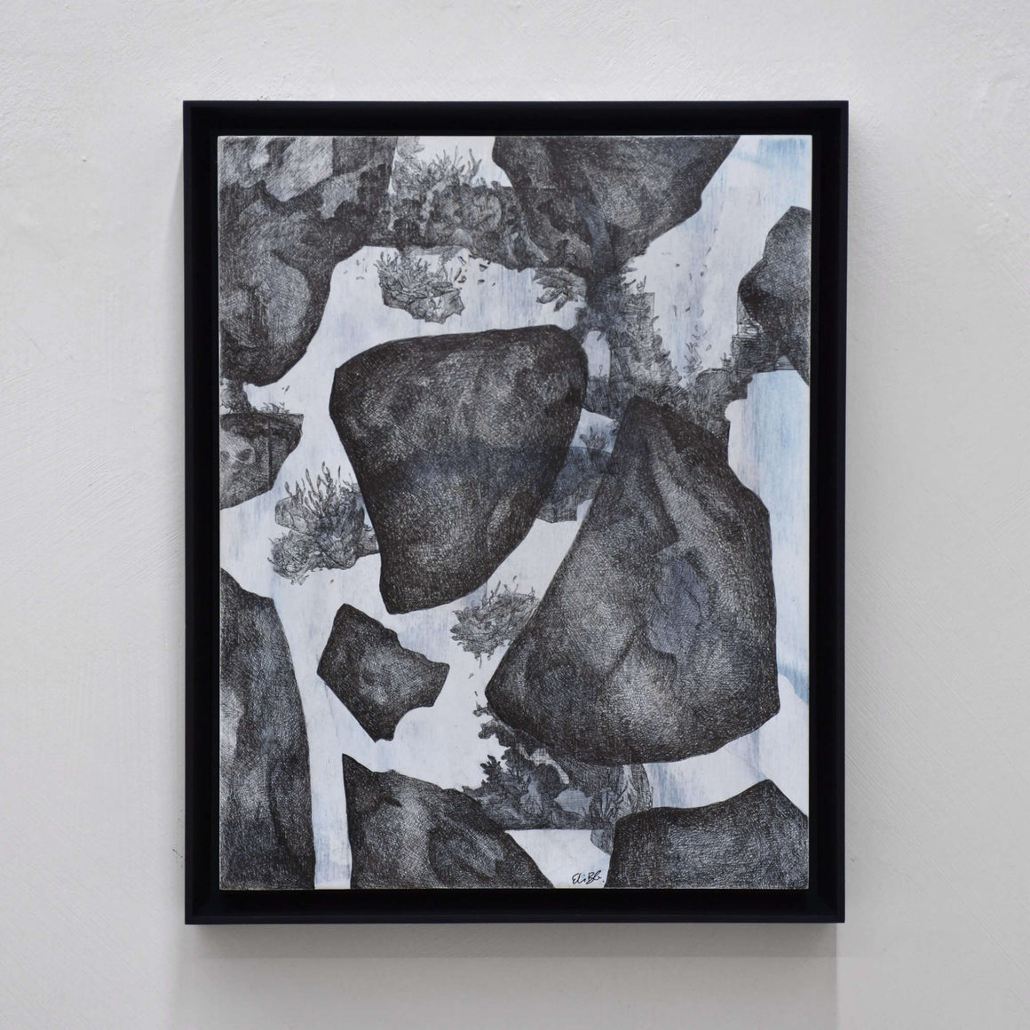 Les ombres suspendues, par Elisabeth Gravel. Dessin à l’encre noir sur panneau de bois vertical, cadre noir. Composition surréaliste de rochers et de végétation.