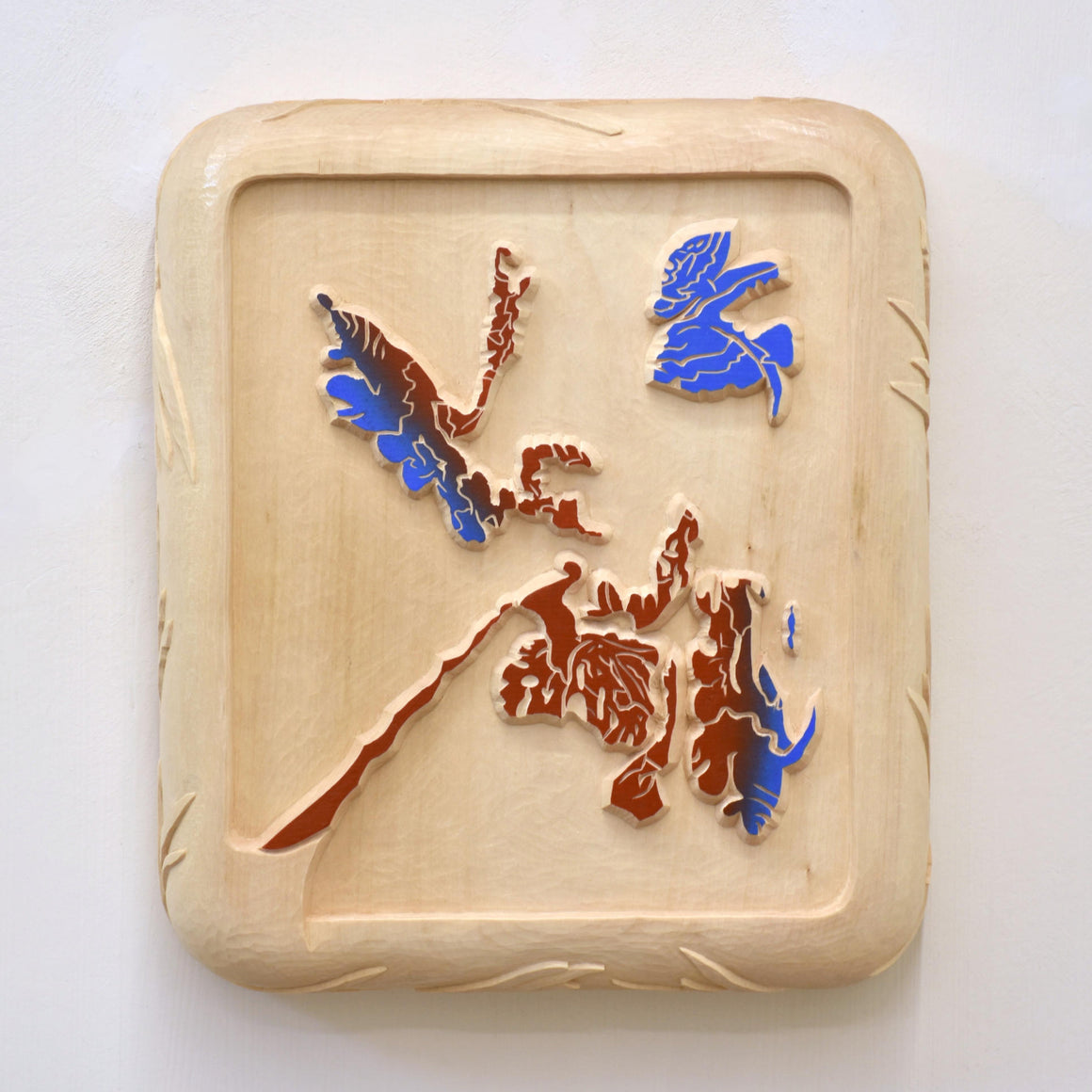 Les sentiers de l’Île d’Entrée, par Marie-Claude Drolet. Relief en trois dimensions sur bois de tilleul, sculpture à la gouge. Motif abstrait bleu et rouge.