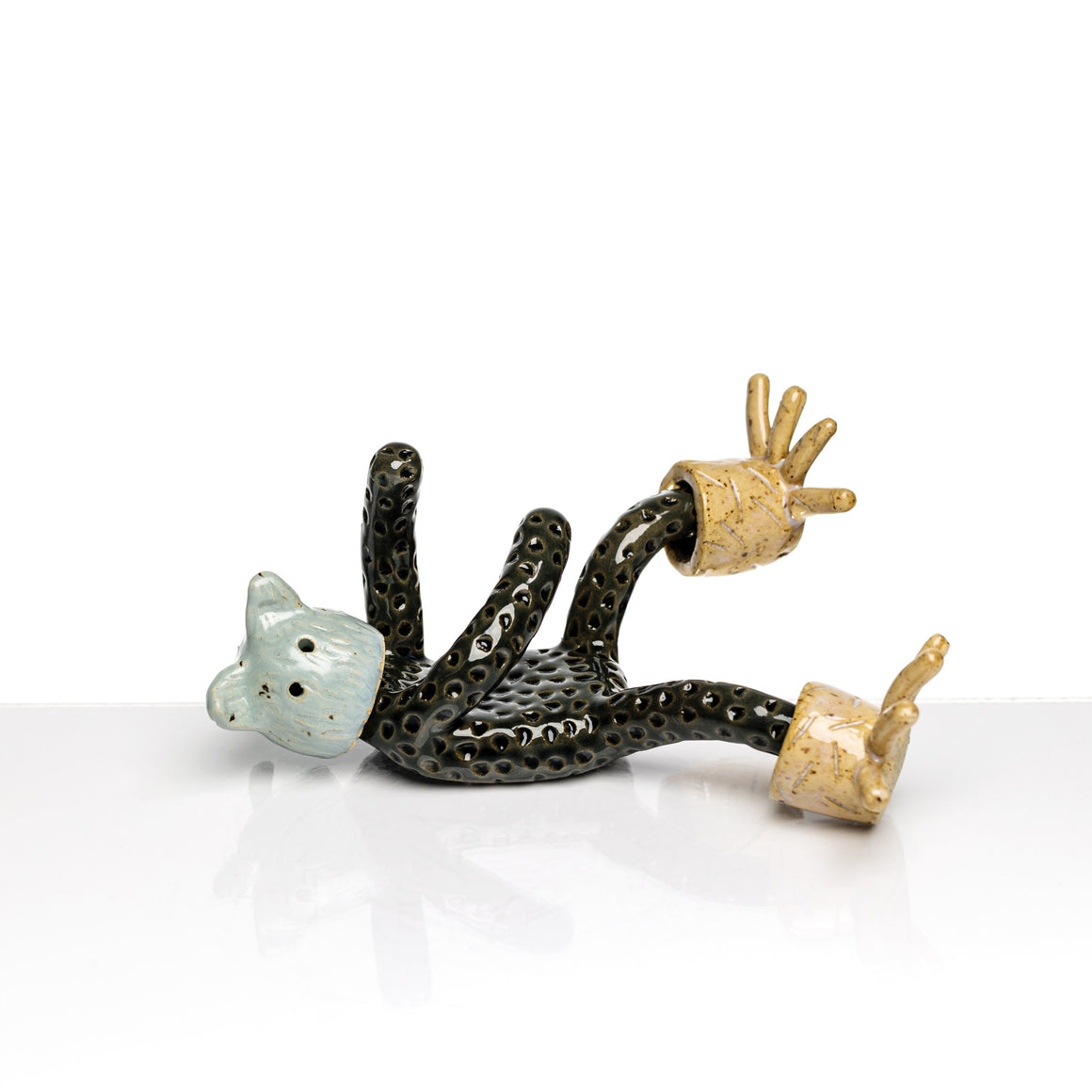 Sculpture en céramique par Fanny Mesnard. Un personnage avec une tête d’ours et d’oiseau est en perte d’équilibre sur le dos.