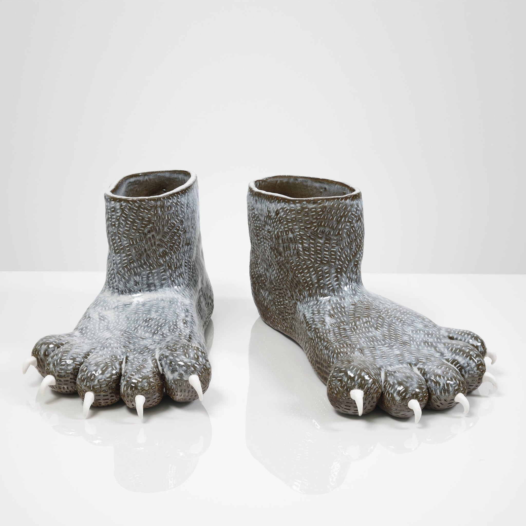 Sculpture de pieds d’ours de Fanny Mesnard. Réalisées en céramique, les pattes sont comme prêtes à être enfilées. 
