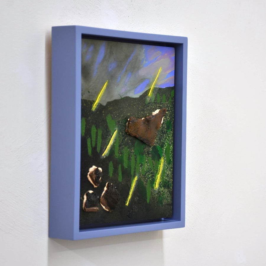 Pluie acide, de Josiane Lanthier. Petit format, acrylique et céramique sur bois, 8” x 10” avec cadre. Pluie jaune sur colline verte, ciel lilas, nuages gris. Cadre violet.