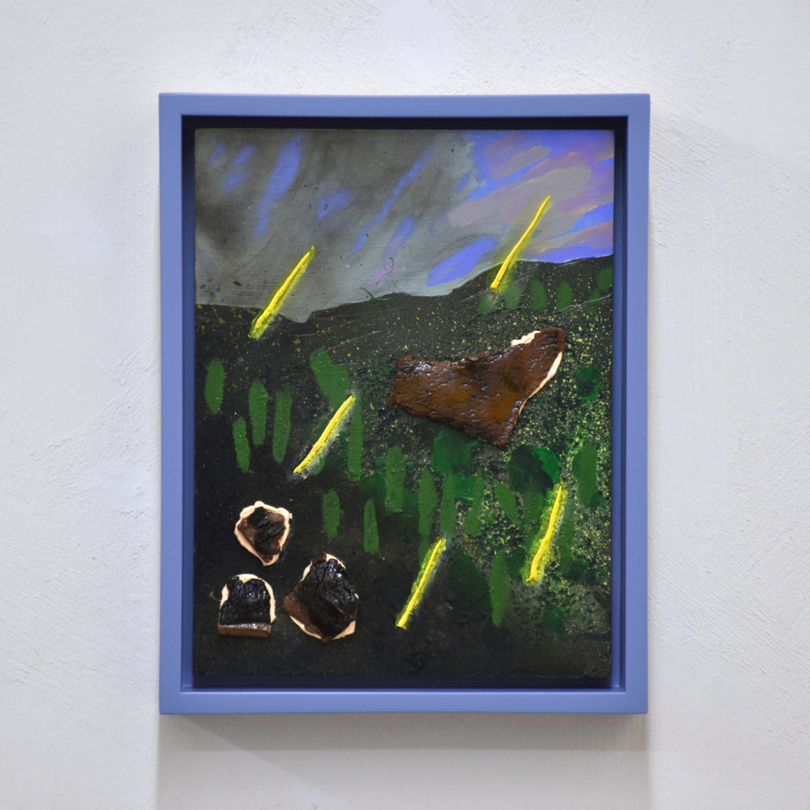 Pluie acide, de Josiane Lanthier. Petit format, acrylique et céramique sur bois, 8” x 10” avec cadre. Pluie jaune sur colline verte, ciel lilas, nuages gris. Cadre violet.