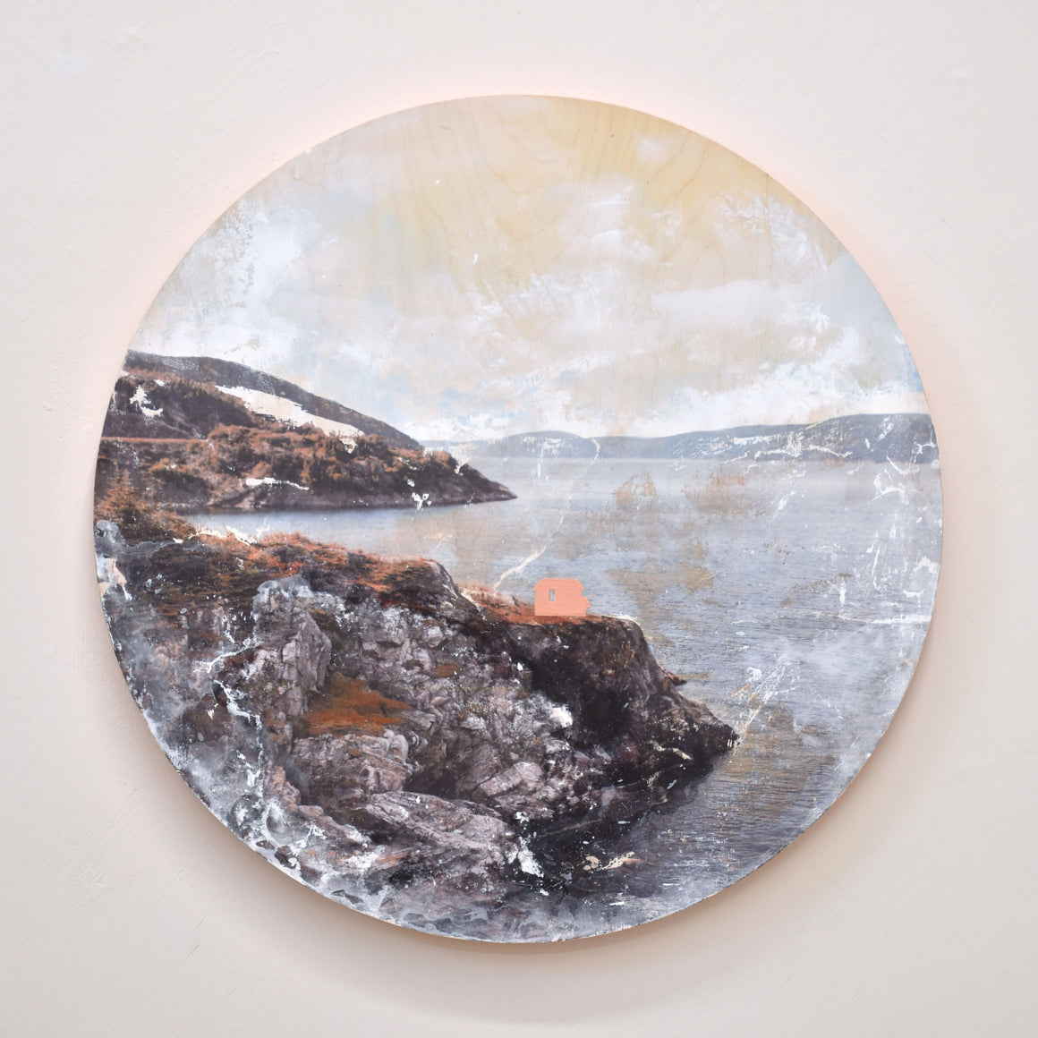 Un tableau circulaire par l’artiste bas-laurentienne Caroline Bolieu. Une maison rose sur une falaise en bordure du fleuve Saint-Laurent.