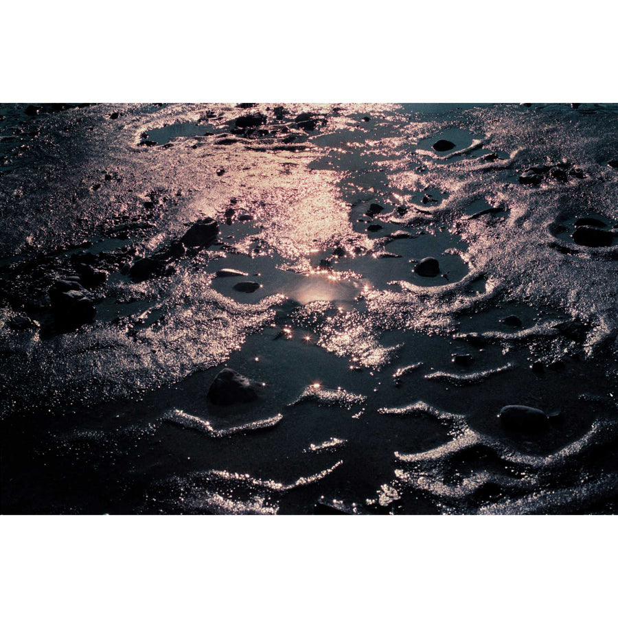 Régolithe terrestre, par Éva-Maude-TC. Photographie contemporaine sur pellicule 35 mm, format horizontal de 24” x 36”. Lumière sur l’eau et le sable à marée basse.