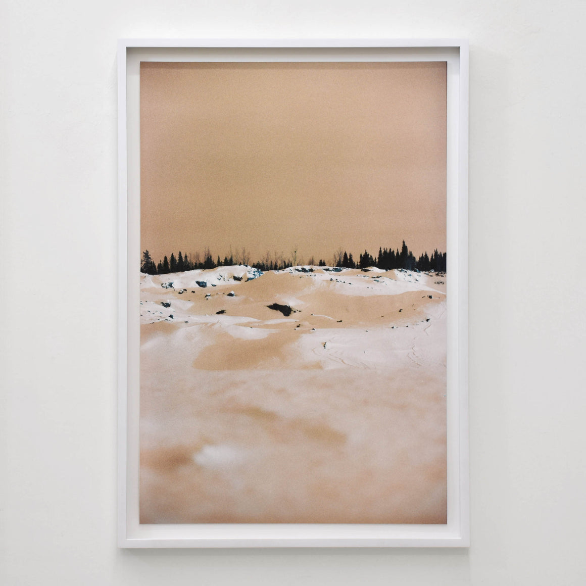 Snow White Meringue d’Éva-Maude TC. Grand tirage photographique d’une composition hivernale, couleur caramel. Horizon noir d’épinettes.