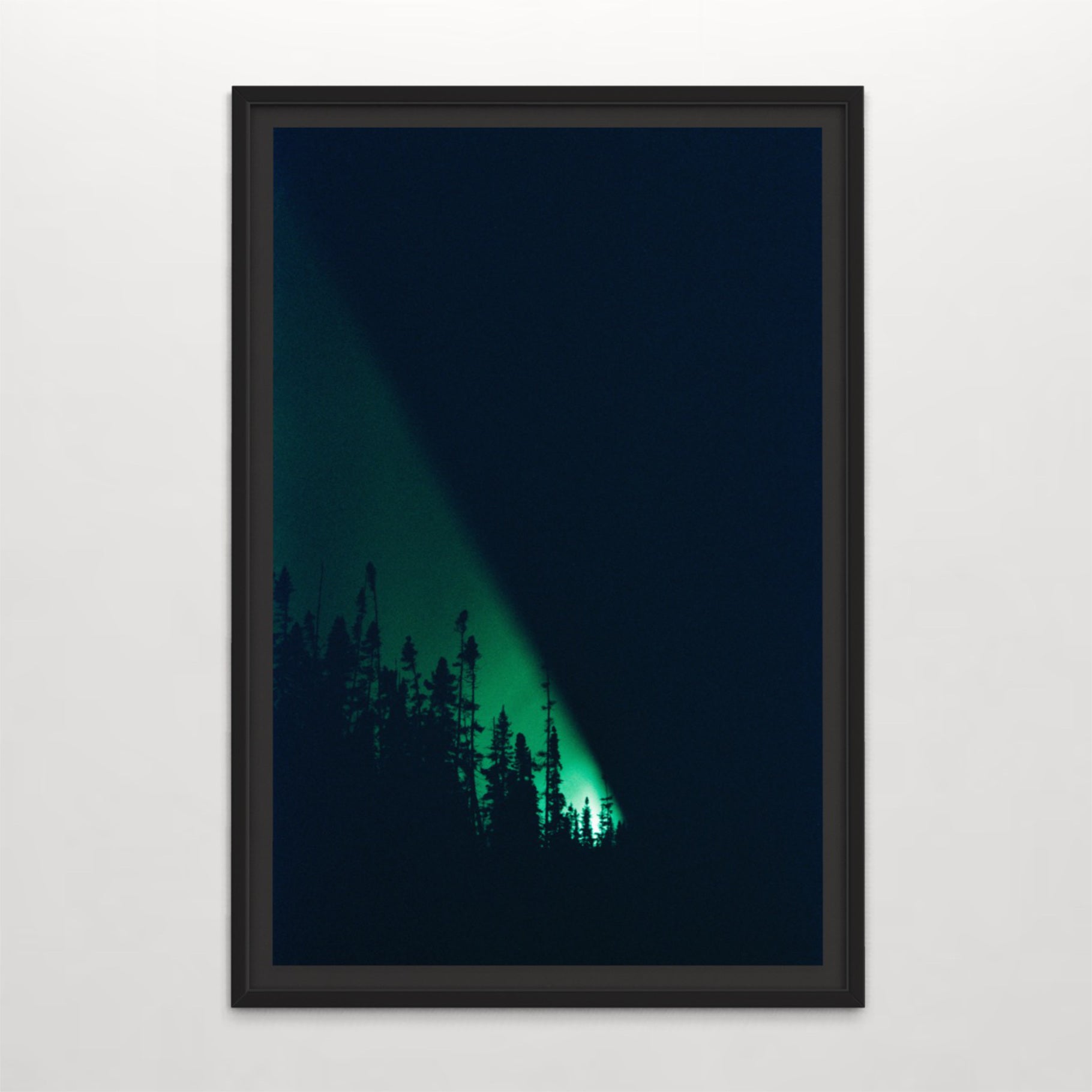 Un phare, la nuit, par Éva-Maude TC. Photographie en clair-obsur sur pellicule 35 mm. Lumière verte dans une nuit noire avec profil d’épinettes.