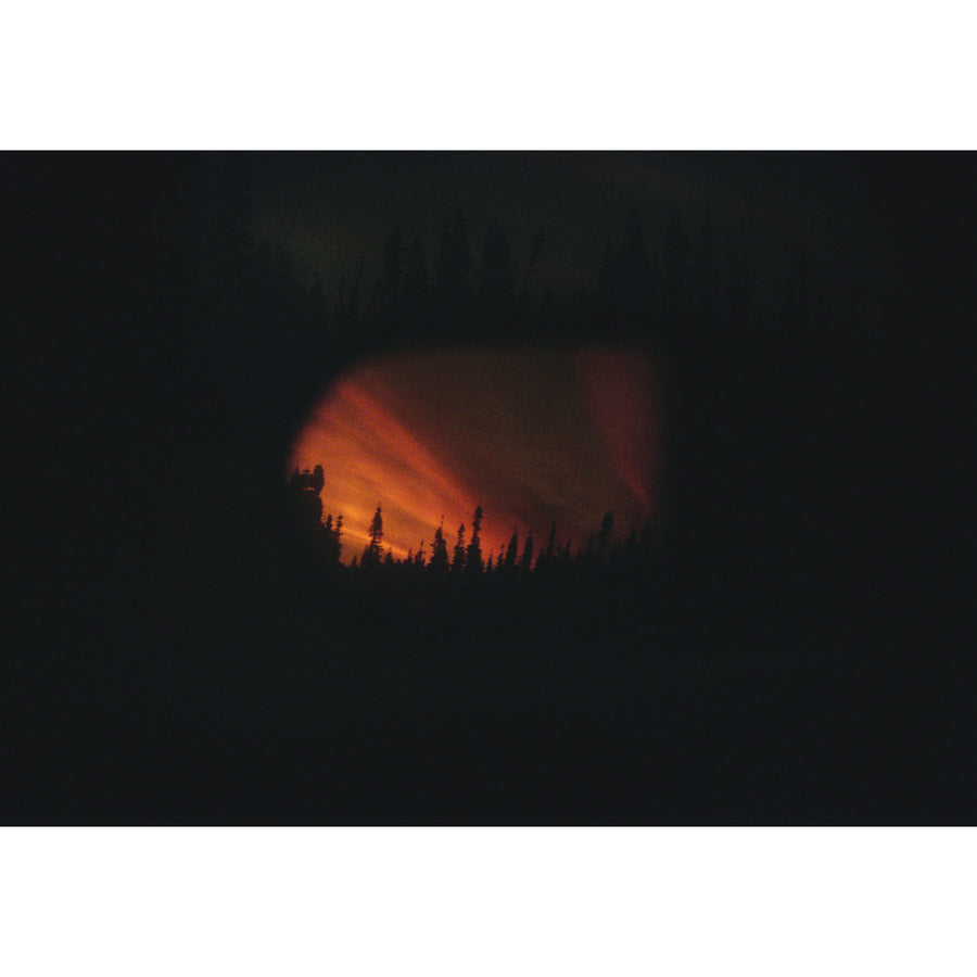 Un reflet, la nuit, par Éva-Maude TC. Photographie contemporaine de paysage sur pellicule 35 mm. Reflet d’un coucher de soleil dans un rétroviseur.