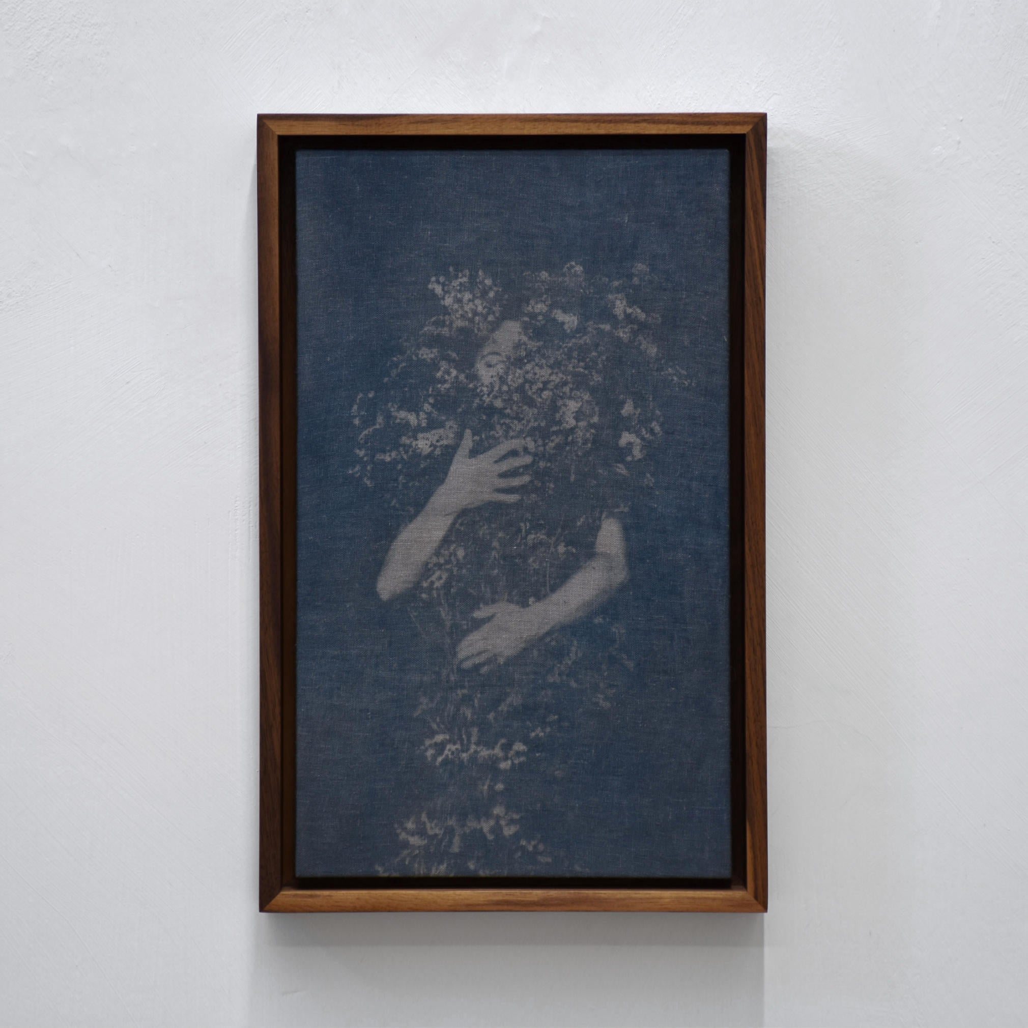 Autoportrait, femme-fleur de Caroline Bolieu. Cyanotype sur toile. Autoportrait d’une femme derrière un bouquet de fleurs sauvages. Cadre en noyer.