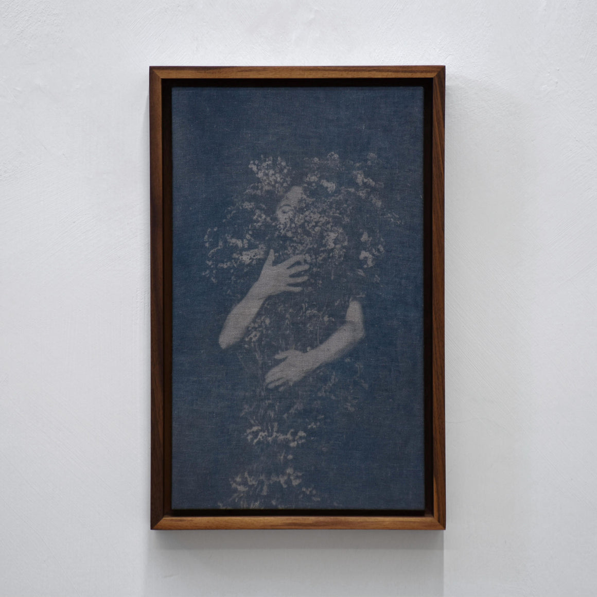 Autoportrait, femme-fleur de Caroline Bolieu. Cyanotype sur toile. Autoportrait d’une femme derrière un bouquet de fleurs sauvages. Cadre en noyer.