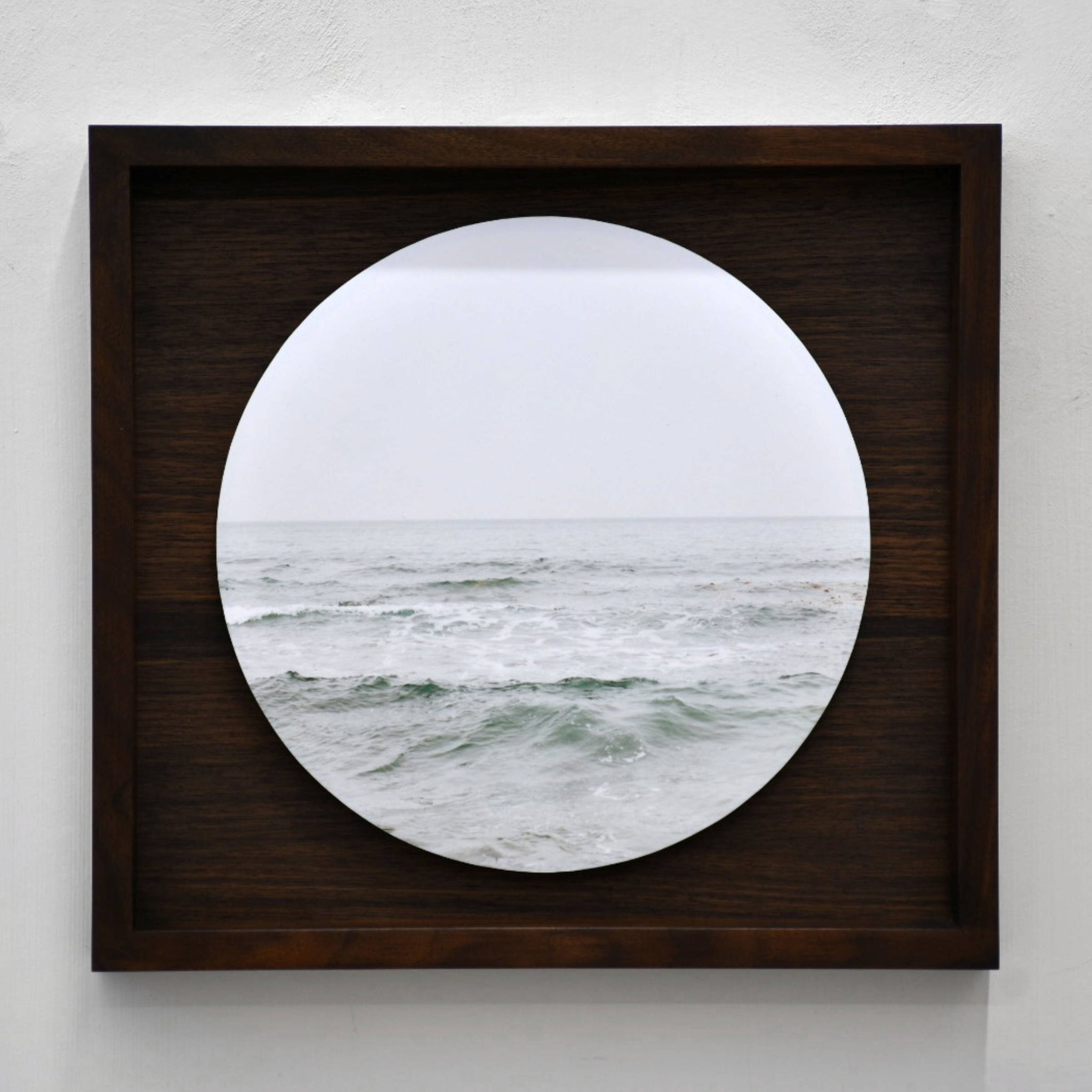 Fleuve Saint-Laurent, par Caroline Bolieu. Photographie circulaire de l’eau du fleuve avec son horizon. Boîtier en noyer.