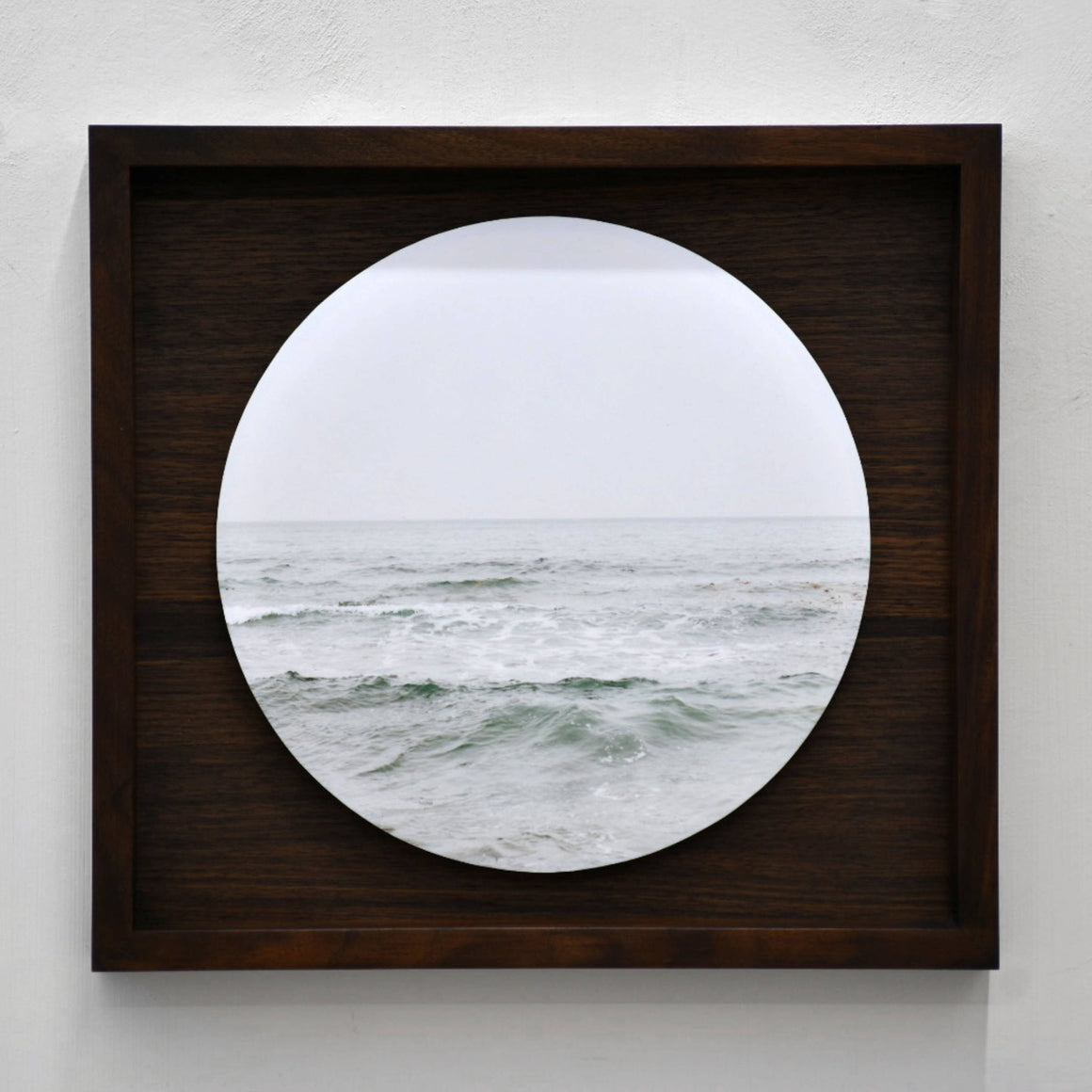 Fleuve Saint-Laurent, par Caroline Bolieu. Photographie circulaire de l’eau du fleuve avec son horizon. Boîtier en noyer.