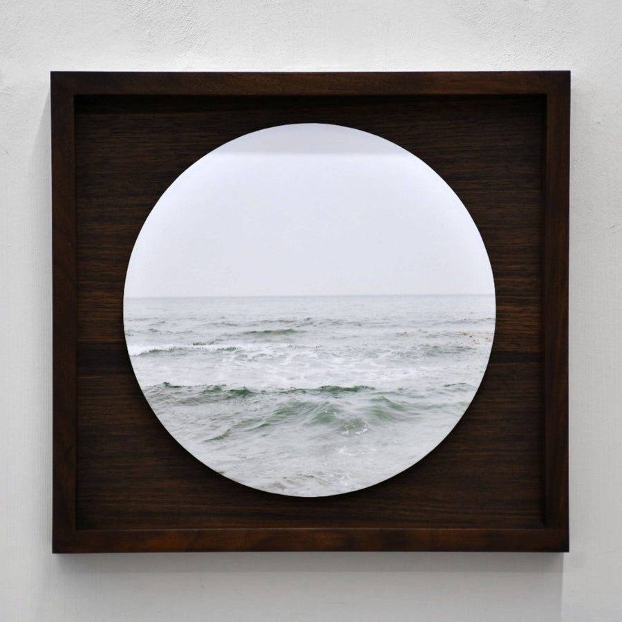 Fleuve Saint-Laurent, par Caroline Bolieu. Photographie circulaire de l’eau du fleuve avec son horizon. Boîtier en noyer.