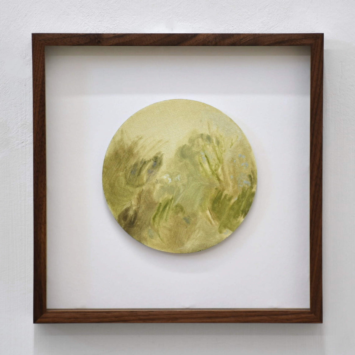 Jardin en juin I, par Vanessa Locatelli. Peinture à l’huile sur carton circulaire, encadrement en noyer de 11” x 11”, 2022. Étude de verts, ambiance de jardin.